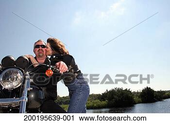 Stock Photography - mature woman kissing 
mature man sitting 
on stationary 
motorbike. fotosearch 
- search stock 
photos, pictures, 
images, and photo 
clipart