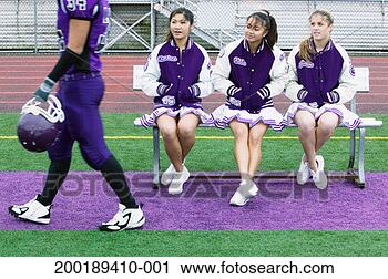 Stock Photography - three female cheerleaders 
(16-18) watching 
football player. 
fotosearch - search 
stock photos, 
pictures, images, 
and photo clipart