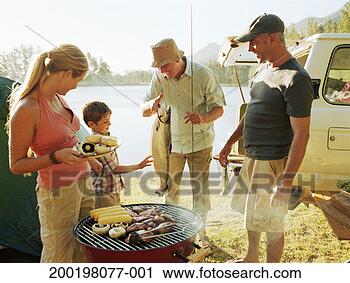 Stock Photography - three generational 
family gathered 
by barbecue grill, 
by lake. fotosearch 
- search stock 
photos, pictures, 
images, and photo 
clipart