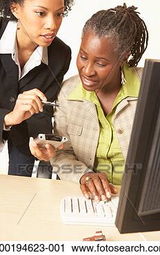 Stock Photography - two businesswomen, 
one using palmtop, 
one using computer. 
fotosearch - search 
stock photos, 
pictures, images, 
and photo clipart