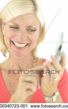 Stock Photography - mature woman pressing 
numbers on mobile 
phone, smiling, 
close-up. fotosearch 
- search stock 
photos, pictures, 
images, and photo 
clipart