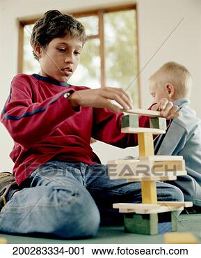 Stock Photography - boy (10-12) building 
tower from toy 
building blocks, 
ground view. fotosearch 
- search stock 
photos, pictures, 
images, and photo 
clipart