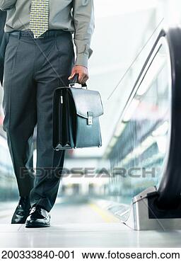 Stock Photography - businessman stepping 
off of escalator, 
carrying briefcase. 
fotosearch - search 
stock photos, 
pictures, images, 
and photo clipart