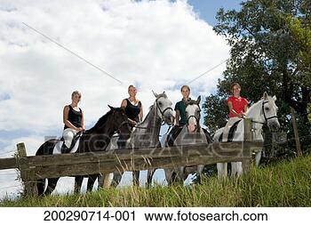 Stock Photography - four teenage girls 
(13-19) on horseback 
behind paddock 
fence, portrait. 
fotosearch - search 
stock photos, 
pictures, images, 
and photo clipart