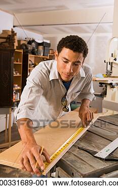 Stock Photography - man measuring 
wood in wood shop. 
fotosearch - search 
stock photos, 
pictures, images, 
and photo clipart