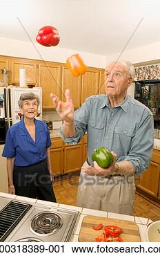 Stock Photography - senior woman watching 
senior man juggle 
bell peppers in 
kitchen. fotosearch 
- search stock 
photos, pictures, 
images, and photo 
clipart