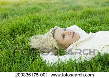 Stock Photography - woman lying on 
grass, hands behind 
head, side view. 
fotosearch - search 
stock photos, 
pictures, images, 
and photo clipart