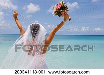 Stock Photography - cayman islands, 
grand cayman, 
bride on beach, 
arms raised, rear 
view. fotosearch 
- search stock 
photos, pictures, 
images, and photo 
clipart