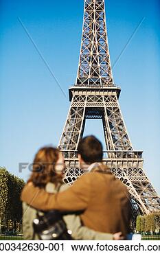 Stock Photography - couple with arms 
around each other 
(focus on eiffel 
tower). fotosearch 
- search stock 
photos, pictures, 
images, and photo 
clipart
