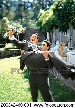 Stock Photography - groom carrying 
best man, best 
man photographing 
himself, smiling. 
fotosearch - search 
stock photos, 
pictures, images, 
and photo clipart