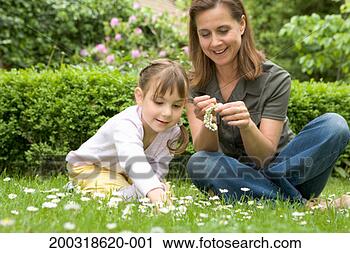 Stock Photography - mother and daughter 
(4-6) making daisy 
chain, smiling, 
ground view. fotosearch 
- search stock 
photos, pictures, 
images, and photo 
clipart