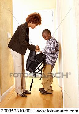 Stock Photography - mother putting 
lunch bag into 
son's (5-7) backpack, 
side view. fotosearch 
- search stock 
photos, pictures, 
images, and photo 
clipart