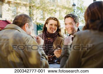 Stock Photography - two couples at 
outdoor cafe (focus 
on couple smiling 
in background). 
fotosearch - search 
stock photos, 
pictures, images, 
and photo clipart