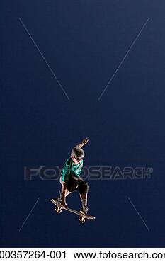 Stock Photography - young man performing 
jump on skateboard, 
low angle view. 
fotosearch - search 
stock photos, 
pictures, images, 
and photo clipart