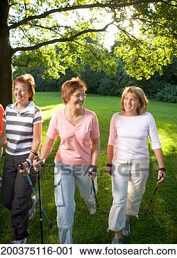 Stock Photography - mature women walking 
on lawn with walking 
sticks, smiling. 
fotosearch - search 
stock photos, 
pictures, images, 
and photo clipart