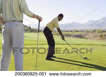 Stock Photography - two men golfing, 
one man lining 
up shot, one man 
waiting. fotosearch 
- search stock 
photos, pictures, 
images, and photo 
clipart