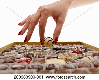 Stock Photography - woman selecting 
chocolate from 
selection box, 
close-up. fotosearch 
- search stock 
photos, pictures, 
images, and photo 
clipart