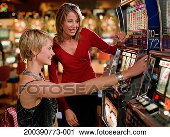 Stock Photography - woman watching 
friend playing 
slot machine in 
casino. fotosearch 
- search stock 
photos, pictures, 
images, and photo 
clipart