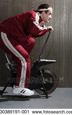 Stock Photography - young man on exercise 
bike, side view. 
fotosearch - search 
stock photos, 
pictures, images, 
and photo clipart