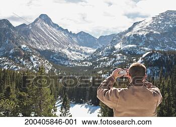 Stock Photography - man on top of 
mountain using 
mobile phone, 
winter. fotosearch 
- search stock 
photos, pictures, 
images, and photo 
clipart