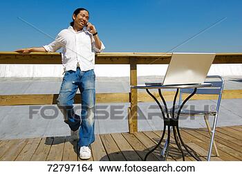 Stock Photo - man standing, 
with laptop, using 
mobile phone. 
fotosearch - search 
stock photos, 
pictures, images, 
and photo clipart