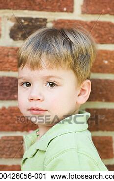 Stock Photography - boy (2-4) standing 
against brick 
wall, portrait. 
fotosearch - search 
stock photos, 
pictures, images, 
and photo clipart