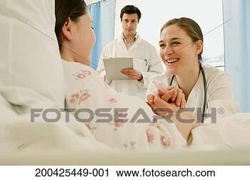 Stock Photography - female doctor 
holding girl's 
(9-11) hand, male 
doctor in background. 
fotosearch - search 
stock photos, 
pictures, images, 
and photo clipart