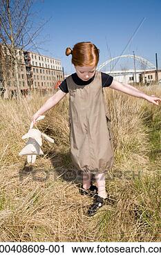 Stock Photography - girl (5-7) with 
stuffed animal 
walking in tall 
grass, looking 
down. fotosearch 
- search stock 
photos, pictures, 
images, and photo 
clipart