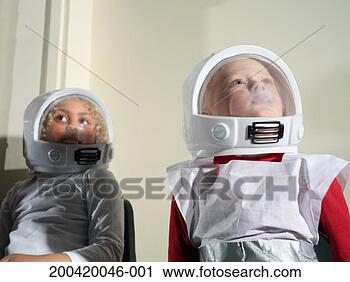 Stock Photography - girl and boy (5-7) 
wearing spacemen 
costumes, looking 
up, close-up. 
fotosearch - search 
stock photos, 
pictures, images, 
and photo clipart