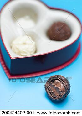 Stock Photography - heart shaped box 
of chocolate (focus 
on chocolate outside 
of box). fotosearch 
- search stock 
photos, pictures, 
images, and photo 
clipart
