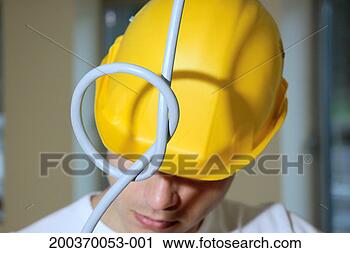 Stock Photography - knot in wire hanging 
down in front 
of man wearing 
hard hat, close 
up. fotosearch 
- search stock 
photos, pictures, 
images, and photo 
clipart