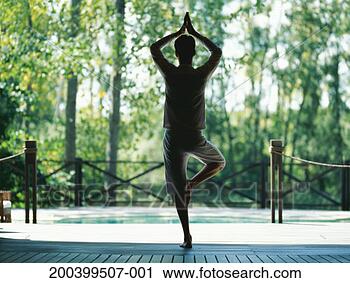 Stock Photography - man balancing 
on one leg performing 
yoga on veranda, 
rear view. fotosearch 
- search stock 
photos, pictures, 
images, and photo 
clipart
