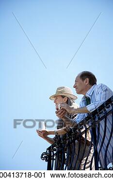 Stock Photography - mature couple 
with mugs on balcony, 
side view, low 
angle view. fotosearch 
- search stock 
photos, pictures, 
images, and photo 
clipart