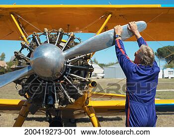 Stock Photography - mature man holding 
propeller of plane, 
rear view. fotosearch 
- search stock 
photos, pictures, 
images, and photo 
clipart