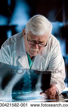 Stock Photography - senior doctor 
looking at x-ray 
on table. fotosearch 
- search stock 
photos, pictures, 
images, and photo 
clipart