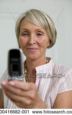Stock Photography - senior woman using 
mobile phone, 
smiling, close-up 
(focus on woman). 
fotosearch - search 
stock photos, 
pictures, images, 
and photo clipart