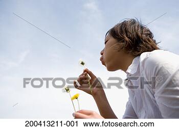 Stock Photography - teenage girl (18-20) 
blowing dandelion, 
low angle view. 
fotosearch - search 
stock photos, 
pictures, images, 
and photo clipart