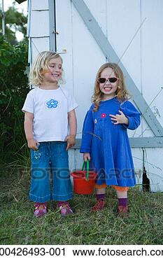 Stock Photography - two girls (2-4) 
standing outdoors, 
smiling, one girl 
holding bucket. 
fotosearch - search 
stock photos, 
pictures, images, 
and photo clipart