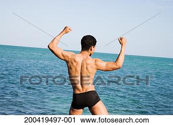 Stock Photography - usa, florida, 
miami, man flexing 
muscles beside 
sea, rear view. 
fotosearch - search 
stock photos, 
pictures, images, 
and photo clipart
