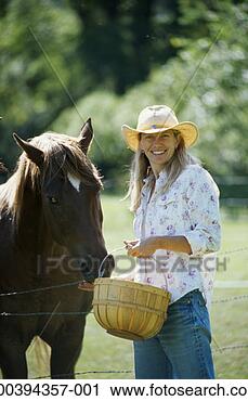 Stock Photography - woman feeding 
quarter horse, 
summer, portrait. 
fotosearch - search 
stock photos, 
pictures, images, 
and photo clipart