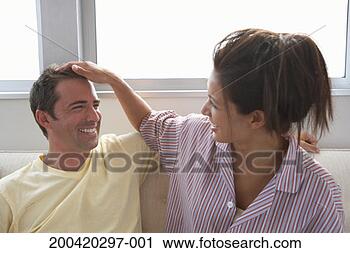 Stock Photography - woman running 
fingers through 
man's hair on 
sofa, laughing. 
fotosearch - search 
stock photos, 
pictures, images, 
and photo clipart