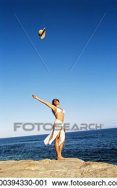 Stock Photography - woman by sea tossing 
hat into air. 
fotosearch - search 
stock photos, 
pictures, images, 
and photo clipart