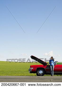 Stock Photography - young woman using 
cell phone beside 
car with hood 
up on side of 
road. fotosearch 
- search stock 
photos, pictures, 
images, and photo 
clipart