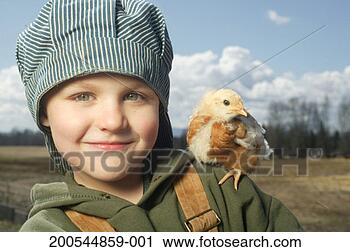 Stock Photography - boy (4-6) with 
chick on shoulder 
at dawn, smiling, 
portrait. fotosearch 
- search stock 
photos, pictures, 
images, and photo 
clipart