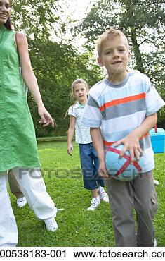 Stock Photography - boy (6-8) carrying 
ball in park with 
mother and sister 
(7-9) portrait. 
fotosearch - search 
stock photos, 
pictures, images, 
and photo clipart