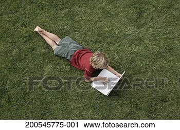 Stock Photography - boy(6-8) lying 
on grass using 
laptop. fotosearch 
- search stock 
photos, pictures, 
images, and photo 
clipart