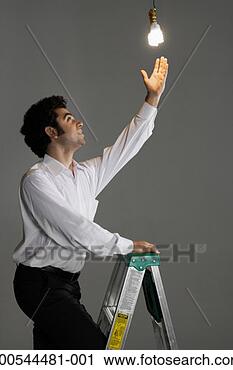 Stock Photography - businessman changing 
light bulb, studio 
shot. fotosearch 
- search stock 
photos, pictures, 
images, and photo 
clipart