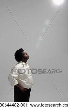 Stock Photography - businessman looking 
up at beam of 
light, studio 
shot. fotosearch 
- search stock 
photos, pictures, 
images, and photo 
clipart