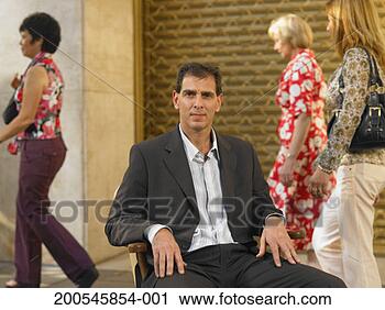 Stock Photography - businessman sitting 
on chair in street, 
portrait, people 
in background. 
fotosearch - search 
stock photos, 
pictures, images, 
and photo clipart
