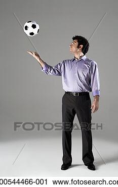 Stock Photography - businessman tossing 
football in air, 
studio shot. fotosearch 
- search stock 
photos, pictures, 
images, and photo 
clipart